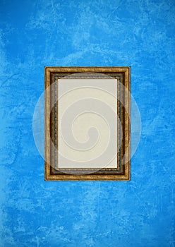 Grunge blue stucco wall with empty picture frame