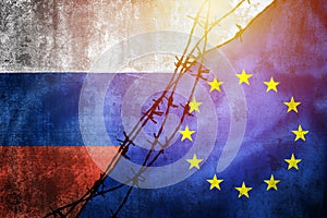Grunge flags of Russia and European Union divided by barb wire sun haze illustration