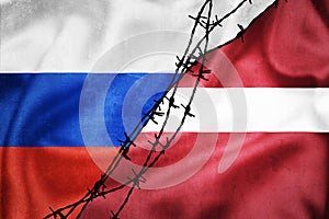 Grunge flags of Russian Federation and Latvia divided by barb wire illustration