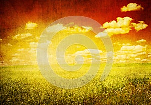 Grunge image of green field and blue sky