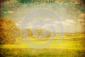 Grunge image of green field and blue sky