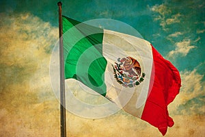 Grunge image of Mexico flag over blue cloudy sky