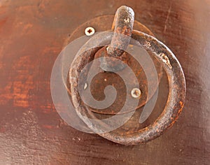 Grunge metal doorknocker on wood