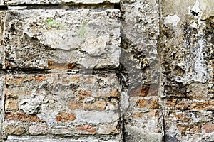 Grunge old bricklaying wall fragment from red bricks and damaged plaster background texture. Close-up