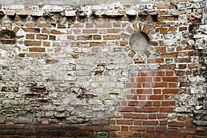 Grunge old bricklaying wall fragment from red bricks and damaged plaster background texture. Close-up