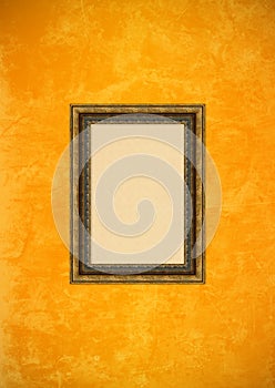 Grunge orange stucco wall with empty picture frame