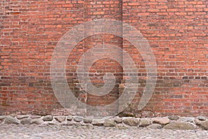 Grunge red brick wall and stone pavement . Urban background