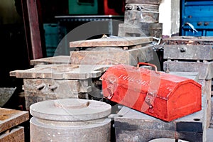 Grunge red metal tool box on rustic moles in factory