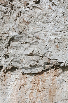 Grunge texture background. An old weathered wall. Plastered stone surface with rocks.