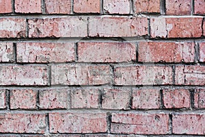 Grunge texture. Mortar-covered red brick wall with very old and cracked stones