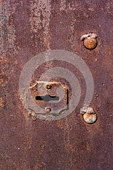 Grunge texture of an old rusty keyhole in a garage door.