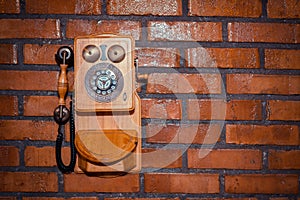 Grunge urban background of a brick wall with an old out of service payphone