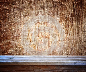 Grunge vintage wooden board table in front of old wooden background