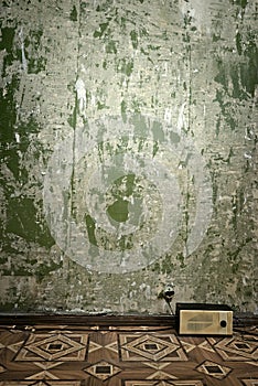 Grunge wall and old radio on floor