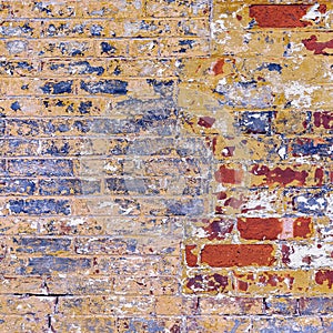 Grunge weathered brick wall red with blue yellow and white peeling paint