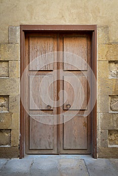 Grunge wooden aged door on grunge stone bricks wall