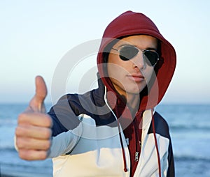 Grunge young man with hood at the beach