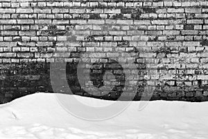 Grungy brick wall texture and pile of snow.