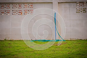 Grungy bronze field faucet connected with blue PVC pipe in white