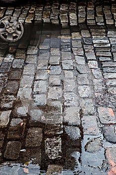 Grungy cobblestone street with puddles, New York City