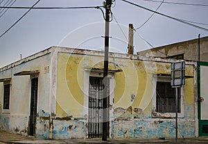 Grungy deteriorated colorful house in town near the sea in Mexico on overcast day