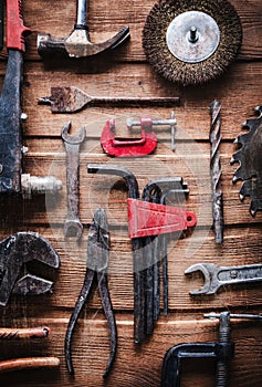 Grungy old metal tools on a wooden background processing cross-process