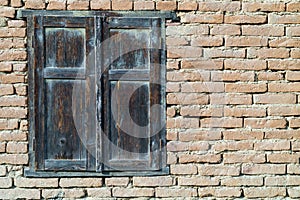 Grungy old red brick wall texture background with deterioration from age. Old wooden window on a old brick wall