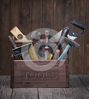 Grungy old tools on a wooden background front view.