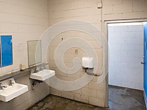 Grungy public washroom sinks faucets and mirror