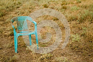 Grungy Retro Damaged Plastic Green Chair Abandoned in a Field