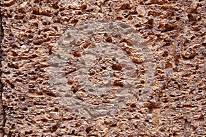 Grungy sandstone surface. Weathered rough texture of natural stone. Porous stone closeup. Ancient rustic surface photo
