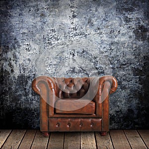 Grungy wall with Classic Brown leather armchair and old wood photo