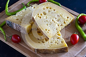 Gruyere cheese on dark background. Close up