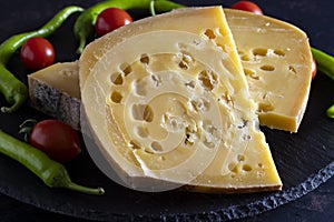 Gruyere cheese on dark background. Close up