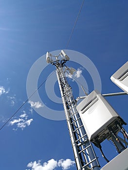GSM base station antenna in front of blue cloudy sky