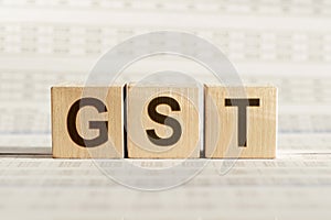 GST acronym for goods and service tax - text on wooden blocks on white background