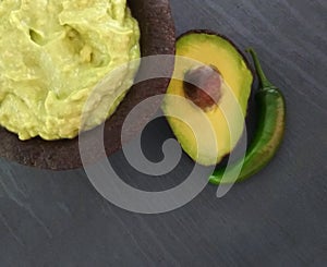 Guac in a traditional Mexican of stone mortar. guacamole in molcajete avocado and chili
