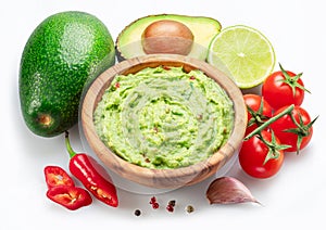 Guacamole bowl and guacamole ingredients isolated on white background. Flat lay