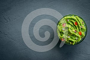 Guacamole bowl on a stone table. Top view image. Copyspace for your text.