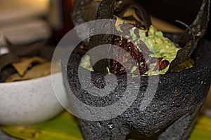 Guacamole with chapulines on molcajete. traditional mexican food