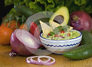 Guacamole, chips and fresh vegetables photo