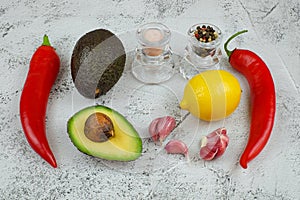 Guacamole ingredients, avocado, red chilli peppers, lemon, garlic, salt and black corn peppers