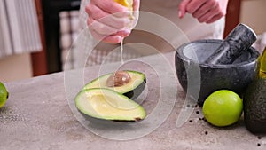 guacamole ingredients - Avocados whole and cut on concrete table with a marble mortar