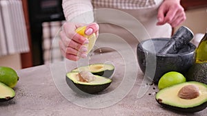 guacamole ingredients - Avocados whole and cut on concrete table with a marble mortar