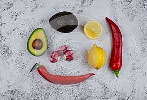 Guacamole ingredients on grey textured backround, top view