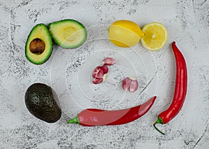 Guacamole ingredients on grey textured backround, top view