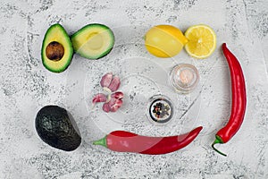 Guacamole ingredients on grey textured backround, top view