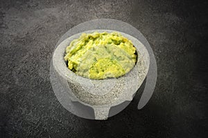 Guacamole in a molcajete, Mexican avocado dip in the traditional stone mortar