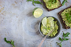 Guacamole and rye toasts on rustic background