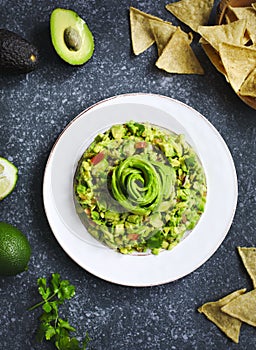 Guacamole and tortilla chips on stone background